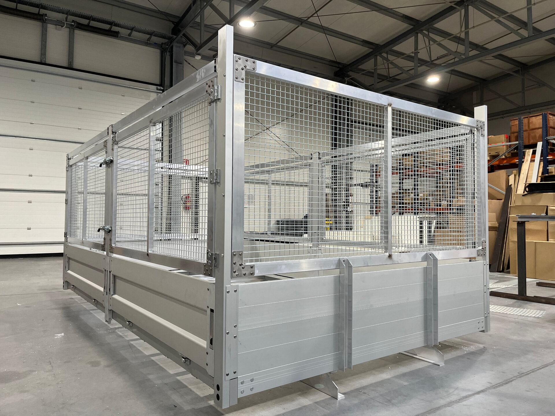 Skrzynia ładunkowa metalowa z siatką w hali produkcyjnej